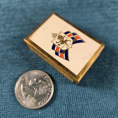 Sale Photo Thumbnail #172: This auction lot is for a WWII British War Relief Match Society Holder. It is brass and enamel with the cardboard match drawer inside.  The one side is engraved - "There will always be an England".  It is in good used condition and contains no matches.