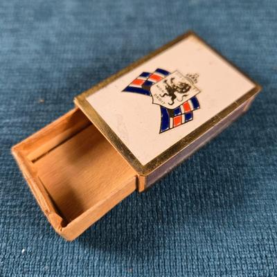 Sale Photo Thumbnail #171: This auction lot is for a WWII British War Relief Match Society Holder. It is brass and enamel with the cardboard match drawer inside.  The one side is engraved - "There will always be an England".  It is in good used condition and contains no matches.