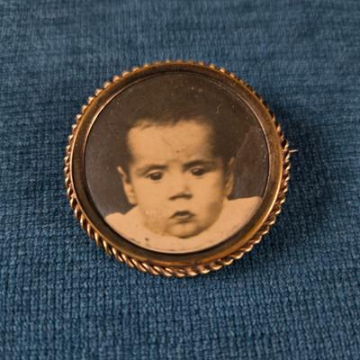 Sale Photo Thumbnail #177: This auction lot is for a Victorian Mourning Broach - #1. This is a very special Victorian Mourning Broach of a baby.  It is nicely framed in a brass broach case with a glass cover that is about  1-3/8-inches in diameter.  It is in very good condition for