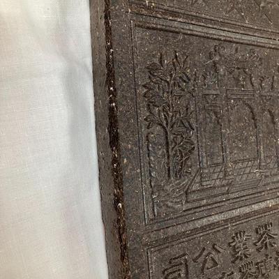 Sale Photo Thumbnail #110: Compressed tea leaves with stamped embossing on a tea brick, measures 9.5"H x 7.5"W