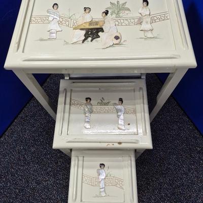 Sale Photo Thumbnail #470: Lovely set of 3 stacking tables in white lacquer 
There are a few small chips in the lacquer
Images in excellent condition 
large is 20 x 14 x 26 inches tall
medium is 13 x 10 x 18 inches tall
small is 9 x 9 x 14 inches tall