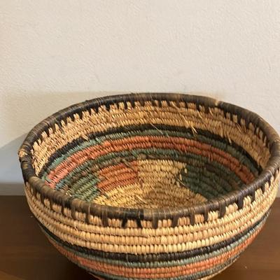 Vintage African coiled basket with multicolor geometric patterns. 9.5” across x 5.5”h
