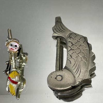 Fish padlock and dancing broom brooch