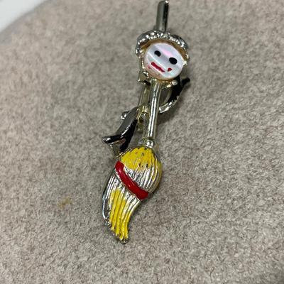 Fish padlock and dancing broom brooch
