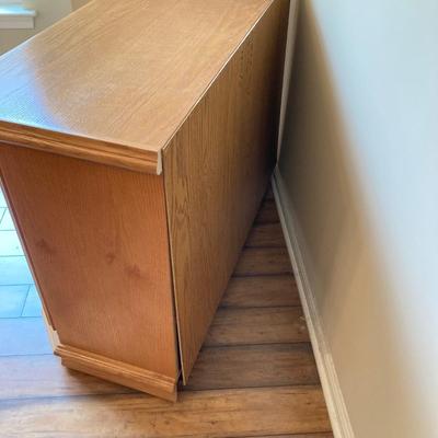 LOT 75: Wooden Storage Cabinet with Framed Magnolia Floral Artwork by Barbara Mock