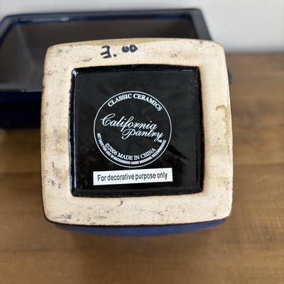 LOT 104: Large Blue Wicker Basket w/Ceramic Handles, LBK Berry Design Pitcher, Blue/White Candlesticks, Metal Flower Vase, Blue Glaze...