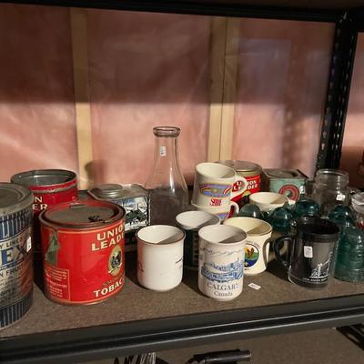 Vintage blue insulators, tin cans, and mugs