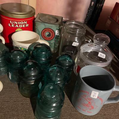 Vintage blue insulators, tin cans, and mugs
