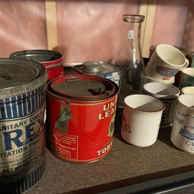 Vintage blue insulators, tin cans, and mugs