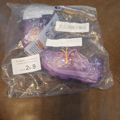 Sale Photo Thumbnail #1282: these show a 20 on the bottom so that would be the EU size.- we recommend you research the size cross reference yourself but it looks like they fit probably a 12 month old   they are new, pink with butterfly.