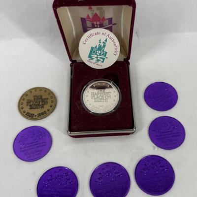 Sale Photo Thumbnail #176: This is a Disneyland 35th Anniversary Commemorative Limited Edition 1 oz Silver Coin set. The set includes a silver coin, a certificate of authenticity, and several purple plastic "doubloons".
