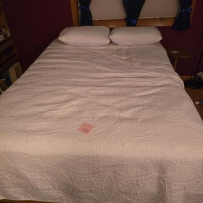 Queen bed with linens.