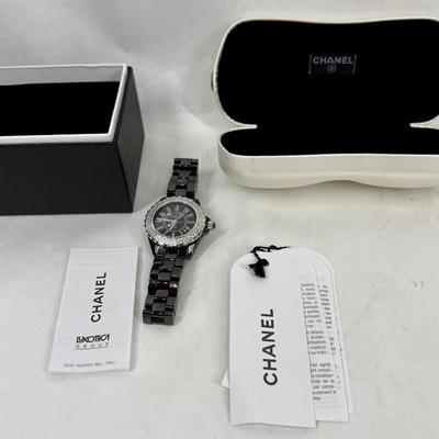 Sale Photo Thumbnail #370: In good used condition. Style is similar to the Chanel J12 Diver's watch, with rotating encrusted bezel.  Not working, may simply need a new battery.  Has a date window on the dial between the 4 & 5 position. Stored in a Chanel Sunglasses case.