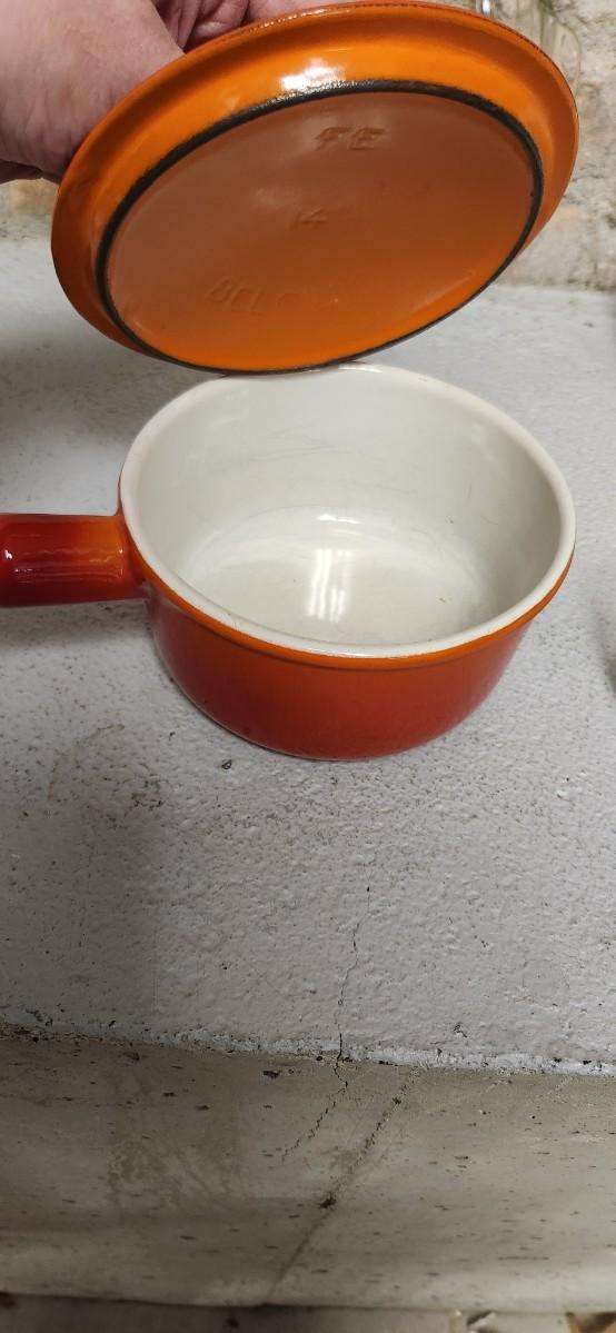 Sale Photo Thumbnail #402: That flame sauce pan enamel over cast with a wooden handle. A couple of pyrex pieces, some vintage lids etc