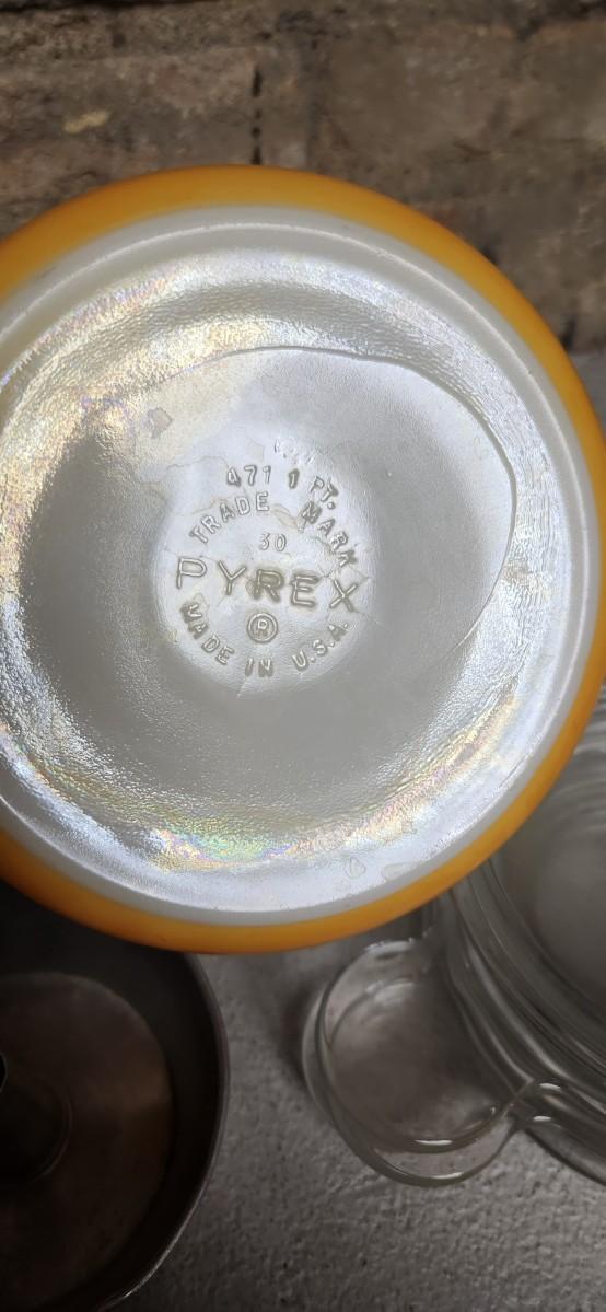 Sale Photo Thumbnail #399: That flame sauce pan enamel over cast with a wooden handle. A couple of pyrex pieces, some vintage lids etc