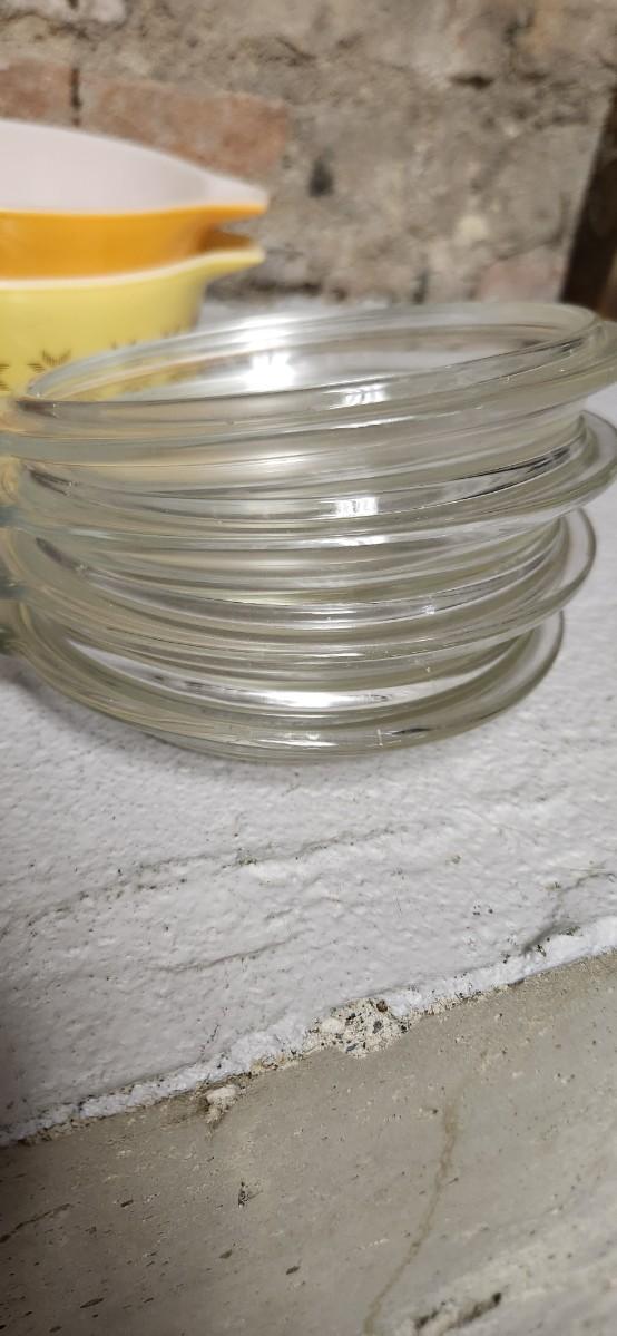 Sale Photo Thumbnail #396: That flame sauce pan enamel over cast with a wooden handle. A couple of pyrex pieces, some vintage lids etc