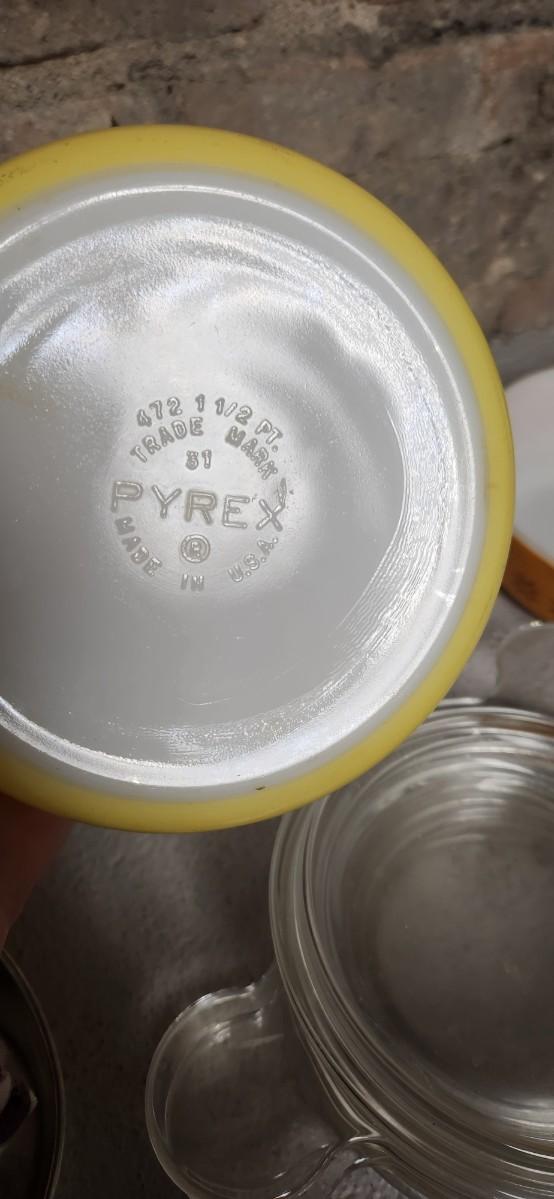 Sale Photo Thumbnail #400: That flame sauce pan enamel over cast with a wooden handle. A couple of pyrex pieces, some vintage lids etc