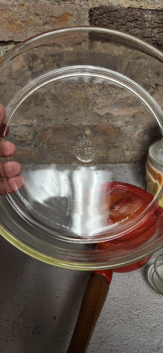 Sale Photo Thumbnail #405: That flame sauce pan enamel over cast with a wooden handle. A couple of pyrex pieces, some vintage lids etc