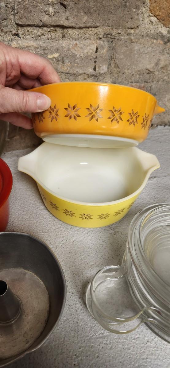 Sale Photo Thumbnail #398: That flame sauce pan enamel over cast with a wooden handle. A couple of pyrex pieces, some vintage lids etc