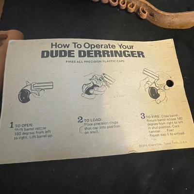 TOY DERRINGER SEALED ON BOARD AND A CHILD'S LEATHER BULLET BELT