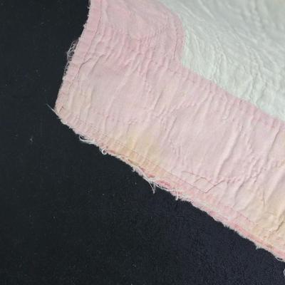 Tin sided luggage with an assortment of vintage children's clothes and baby quilt