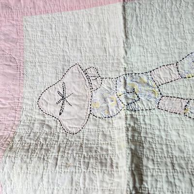 Tin sided luggage with an assortment of vintage children's clothes and baby quilt