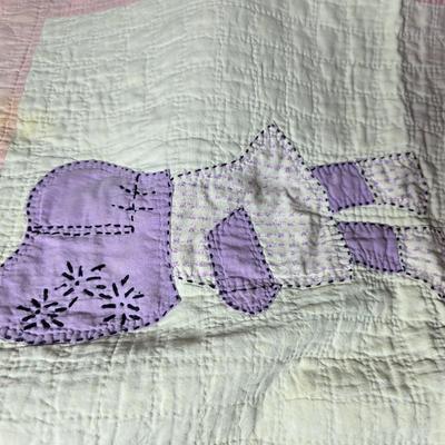 Tin sided luggage with an assortment of vintage children's clothes and baby quilt