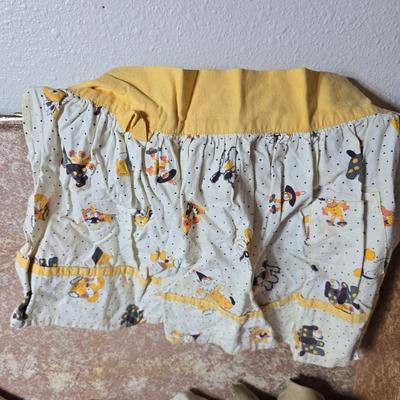 Tin sided luggage with an assortment of vintage children's clothes and baby quilt