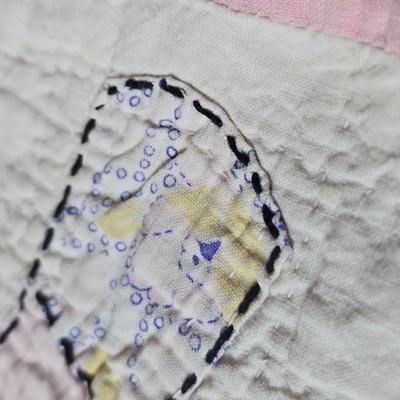 Tin sided luggage with an assortment of vintage children's clothes and baby quilt