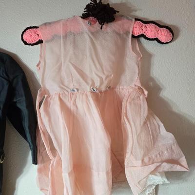 Tin sided luggage with an assortment of vintage children's clothes and baby quilt