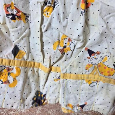 Tin sided luggage with an assortment of vintage children's clothes and baby quilt