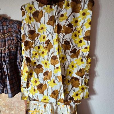 Tin sided luggage with an assortment of vintage children's clothes and baby quilt