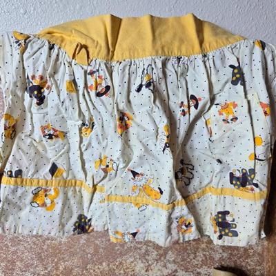 Tin sided luggage with an assortment of vintage children's clothes and baby quilt