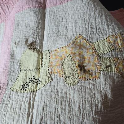 Tin sided luggage with an assortment of vintage children's clothes and baby quilt