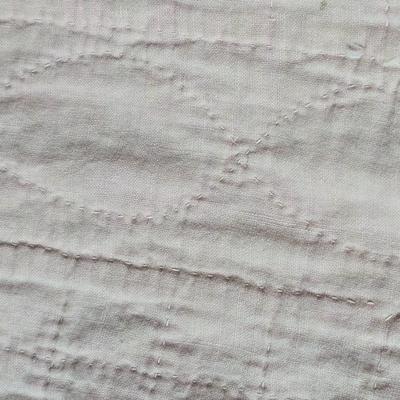 Tin sided luggage with an assortment of vintage children's clothes and baby quilt