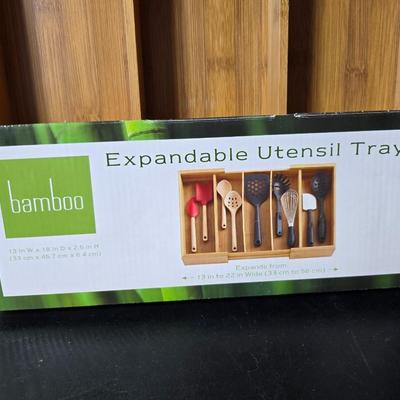 Bamboo Expandable utensil tray with an assortment of utensils and two cat themed dish towels