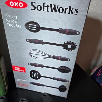 Bamboo Expandable utensil tray with an assortment of utensils and two cat themed dish towels