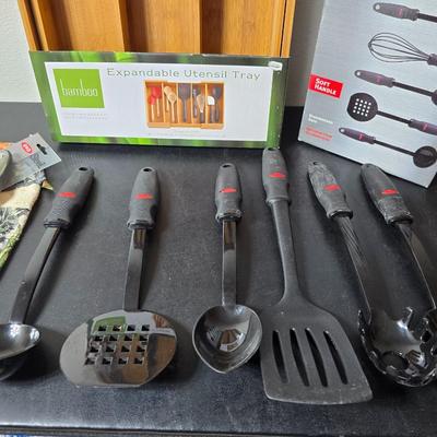 Bamboo Expandable utensil tray with an assortment of utensils and two cat themed dish towels