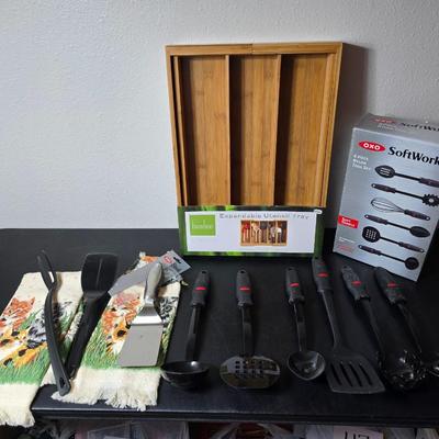 Bamboo Expandable utensil tray with an assortment of utensils and two cat themed dish towels