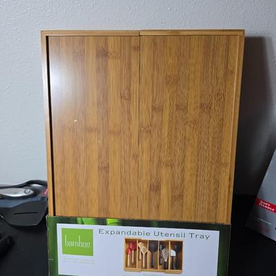 Bamboo Expandable utensil tray with an assortment of utensils and two cat themed dish towels