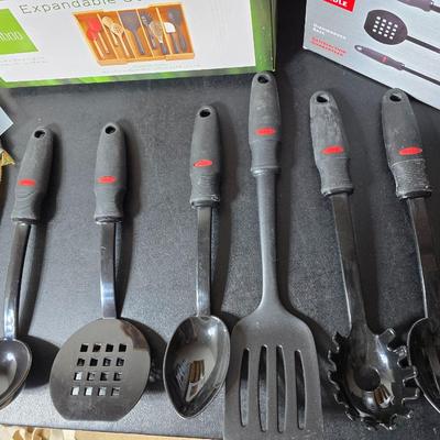 Bamboo Expandable utensil tray with an assortment of utensils and two cat themed dish towels