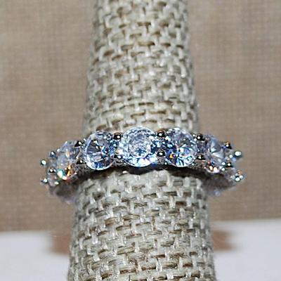 Size 9 Very Interesting Infinity Style Ring with Single Main Stone & FULL Band of Round Clear Stones on a Silver Tone Band (8.9g)