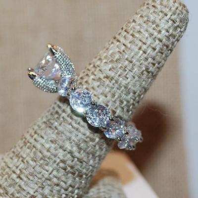 Size 9 Very Interesting Infinity Style Ring with Single Main Stone & FULL Band of Round Clear Stones on a Silver Tone Band (8.9g)