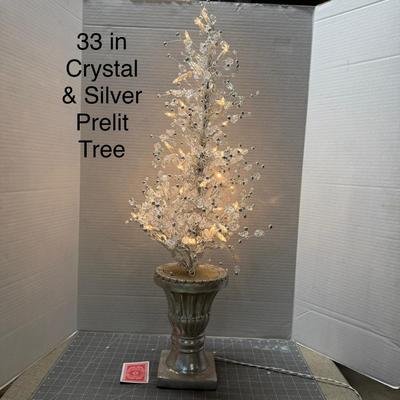 Sale Photo Thumbnail #143: Elegant decorative lighted tree with silver base and crystals.
