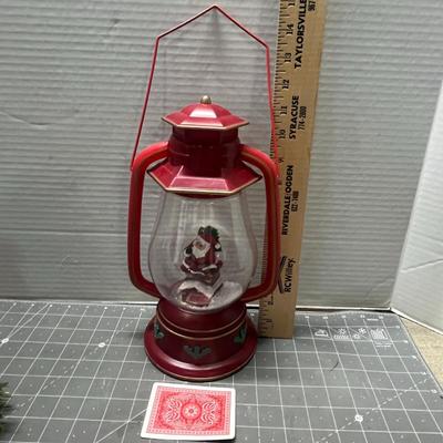 Sale Photo Thumbnail #412: Red lantern with Santa, glass candle holder, pine, berries.