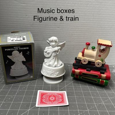 Sale Photo Thumbnail #636: Porcelain angel, wooden train music box on red-green base.
