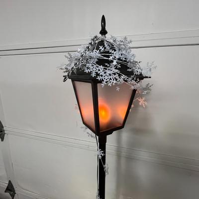 Sale Photo Thumbnail #703: Black lamp post, glowing lantern, snowy top, festive decorated base.
