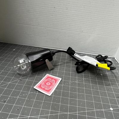 Sale Photo Thumbnail #760: Black cylindrical lamp, textured dome, glowing red reflections.