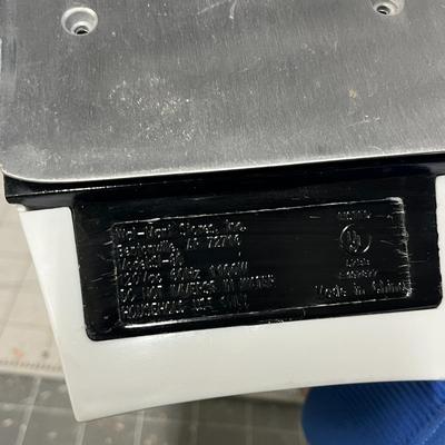 Sale Photo Thumbnail #1146: Electric iron with steam holes, green handle, black soleplate, corded.