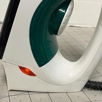 Sale Photo Thumbnail #1147: Electric iron with steam holes, green handle, black soleplate, corded.